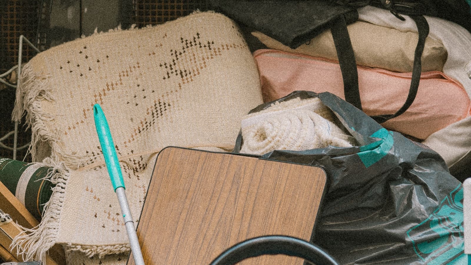 Rolled rugs, bagged household items and a wooden table top packed tightly into a loaded removal vehicle