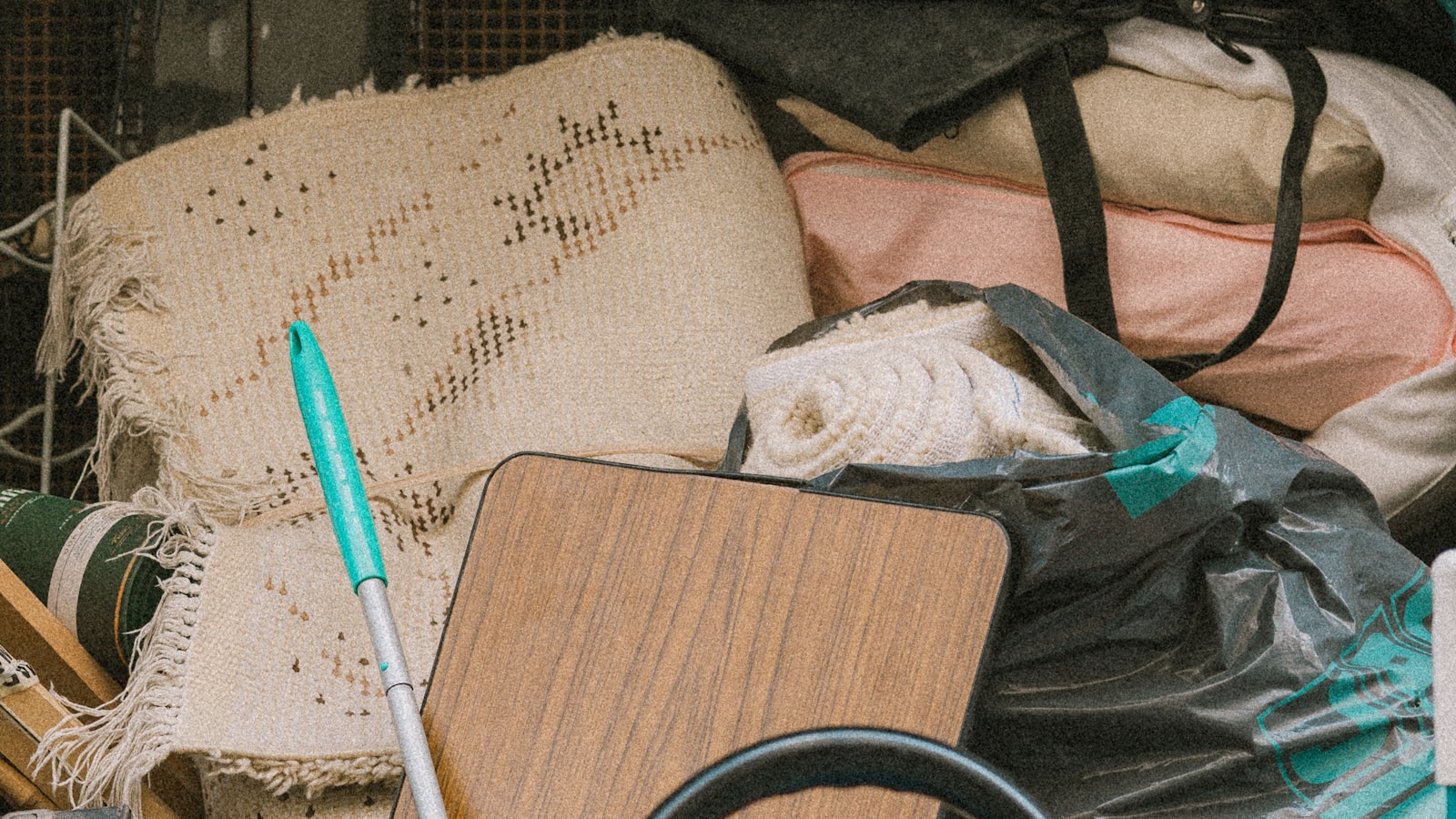 Rolled rugs, bagged household items and a wooden table top packed tightly into a loaded removal vehicle