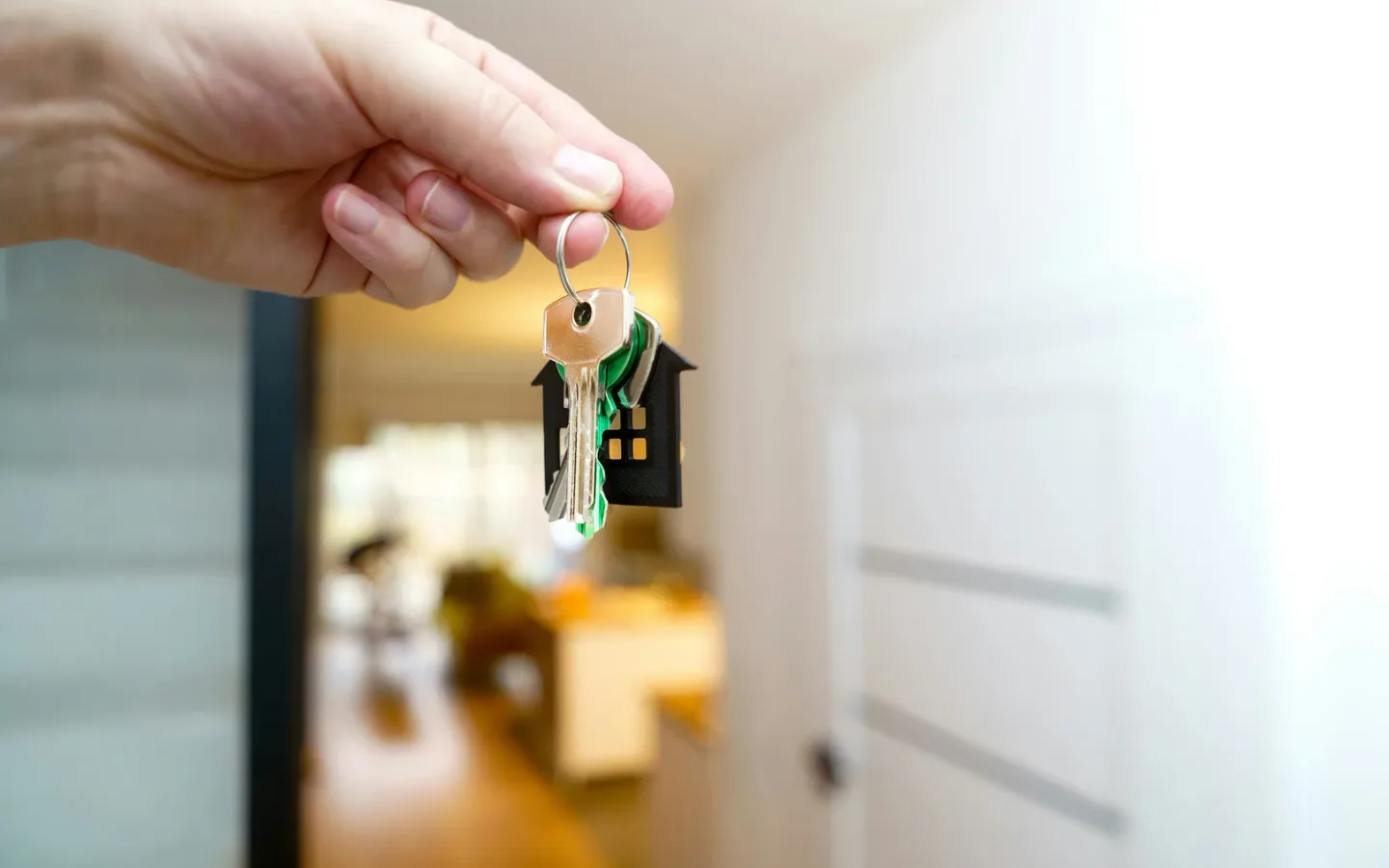 Hand holding keys at a Dubai apartment doorway during tenancy handover