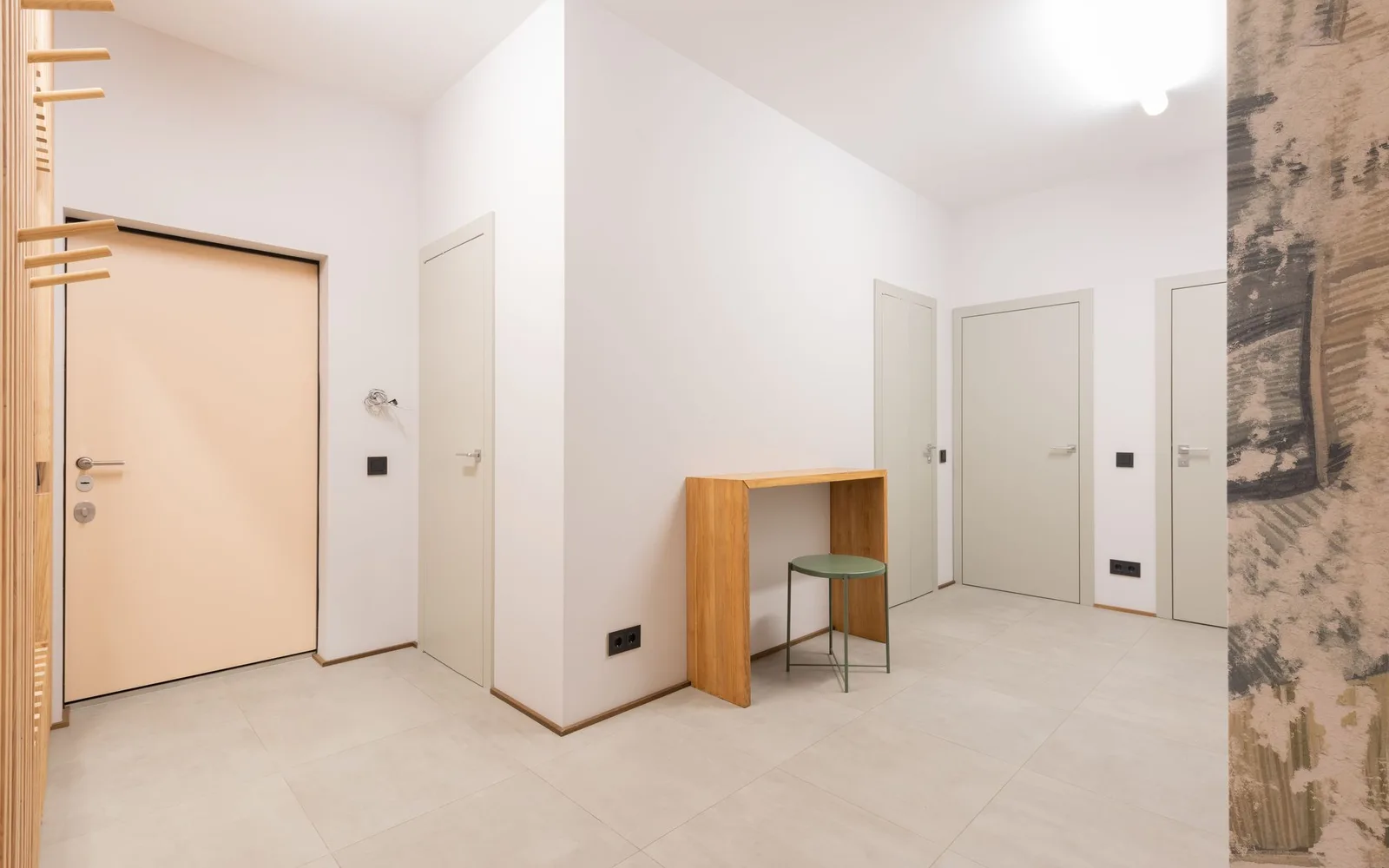 Empty modern apartment hallway with a clear tiled route between closed doors