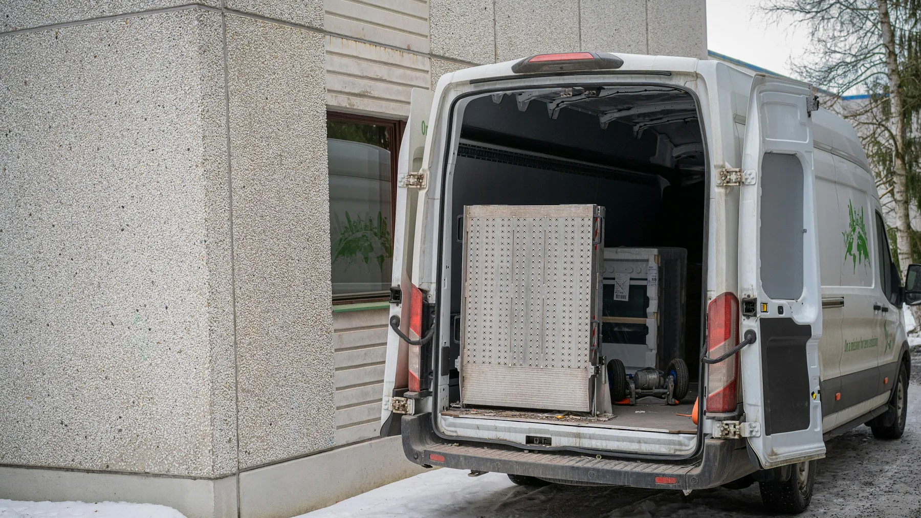 Open cargo area of a transport vehicle loaded with secured cardboard boxes and equipment
