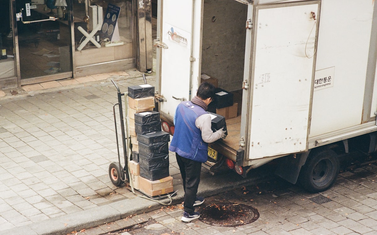Junk removal Dubai crew loading boxes from a truck onto a dolly